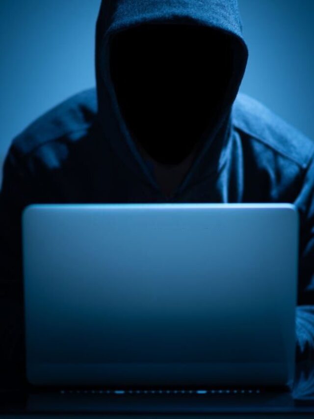 Hacker dark face using laptop in the dark room